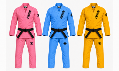 Three martial arts gi uniforms displayed side by side on a light gray background: pink, blue, and yellow, each with a black belt and the brand name PHENOM printed on the chest.