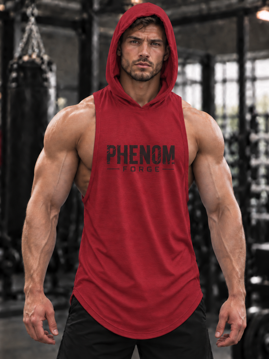 A muscular man wearing a red sleeveless hooded tank top with 'PHENOM FORGE' printed in black across the chest, standing in a gym with a blurred background.