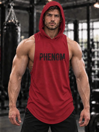 A muscular man wearing a red sleeveless hooded tank top with 'PHENOM FORGE' printed in black across the chest, standing in a gym with a blurred background.