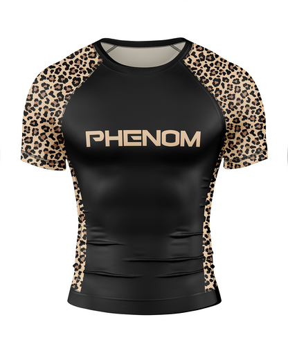 A short-sleeve athletic rash guard with a black body and leopard print raglan sleeves, featuring the word 'PHENOM' printed in beige across the chest.